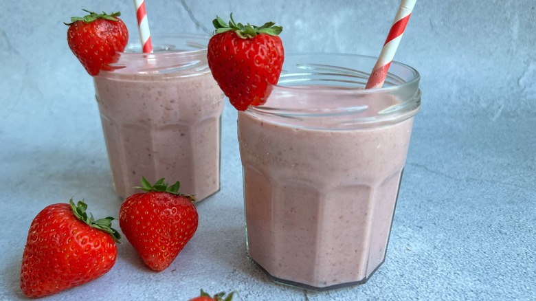 strawberry smoothie in glass jar with straw