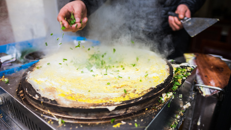 jianbing/Chinese crepe being made at a food stall 