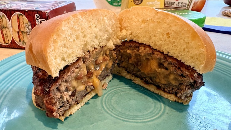 A cooked burger stuffed with bacon, onion, and cheese made with the Stufz burger press