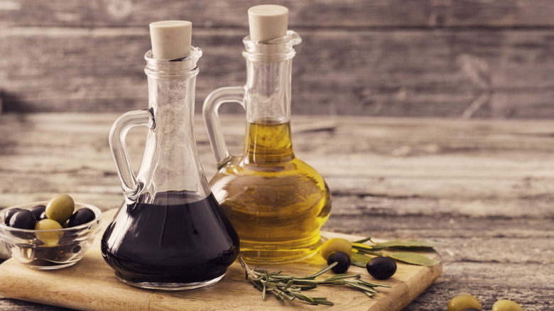 Oil and vinegar bottles on a wooden board