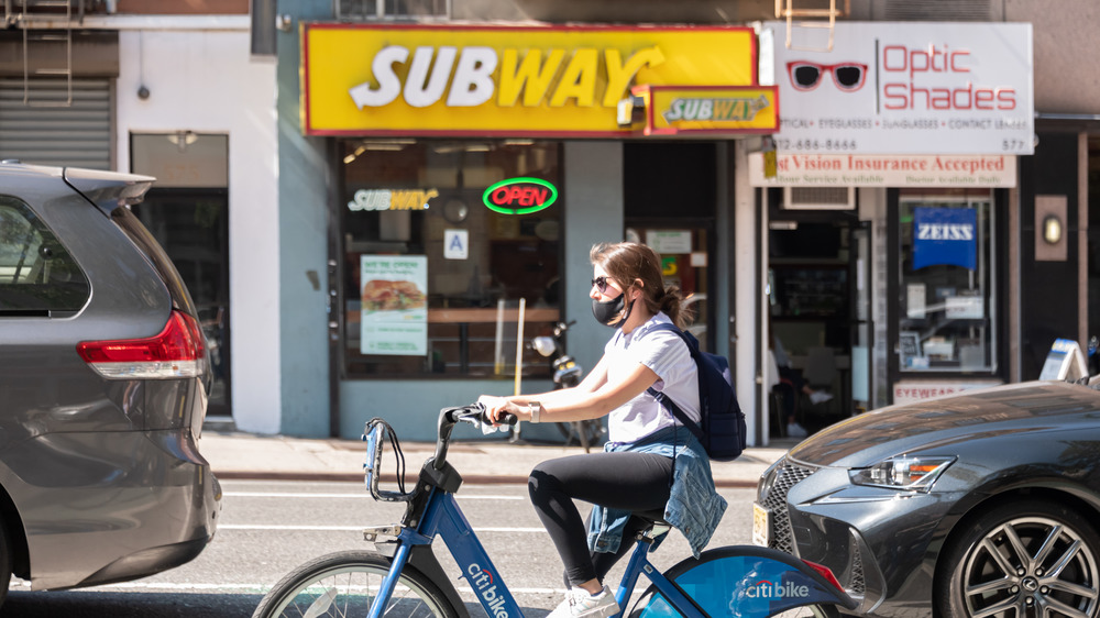 Woman riding a bike outside of Subway