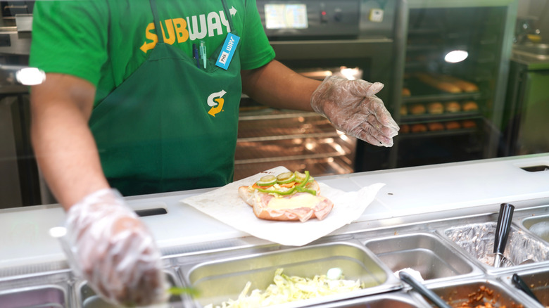 Subway employee preparing a sandwich