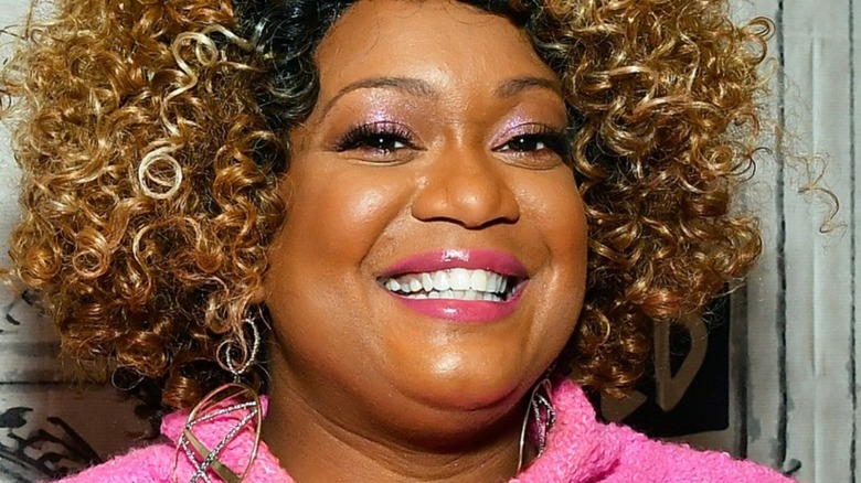 Sunny Anderson in pink top smiling