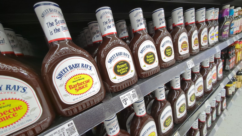Bottles of Sweet Baby Ray's barbecue sauce lined up on grocery store shelf.