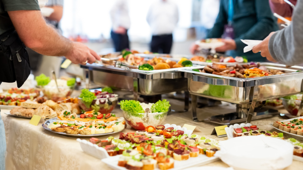 People getting food from a snack table