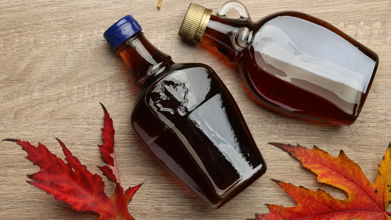 Maple syrup bottles against wooden background