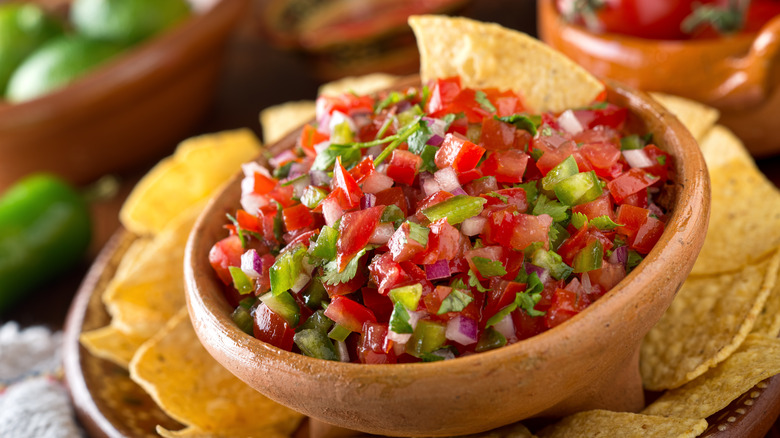 Pico de gallo in a brown bowl and chips