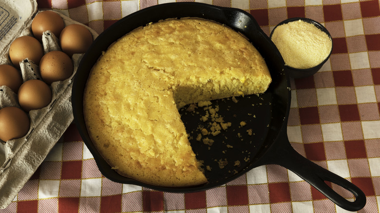 Cornbread made in a cast iron pan with eggs on the side.