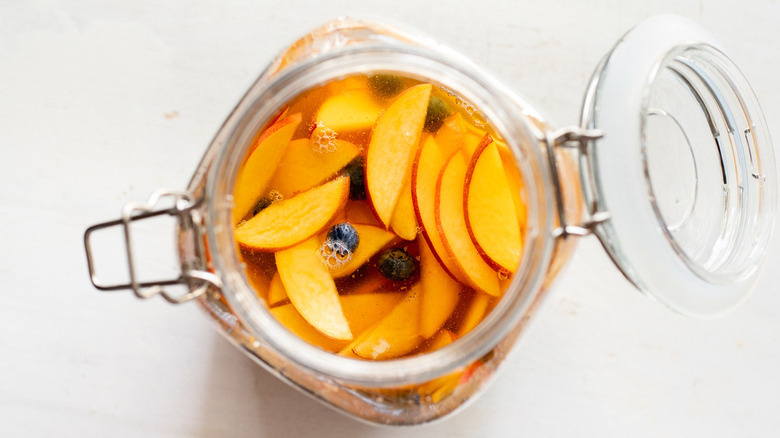   buah persik dan cairan dalam teko