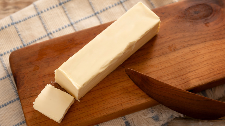 Single stick of butter on a wood cutting board