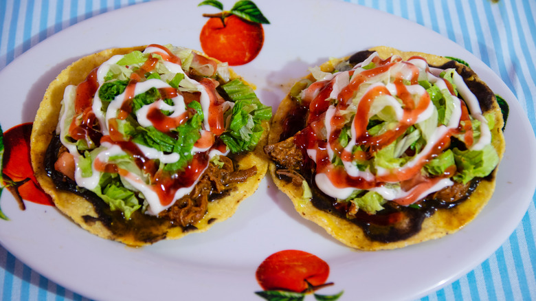 Two plated chalupas on striped tablecloth