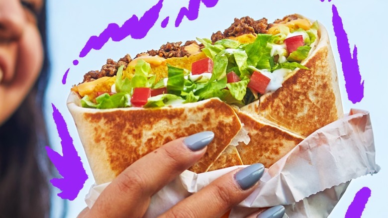 Hand holding Crunchwrap Supreme