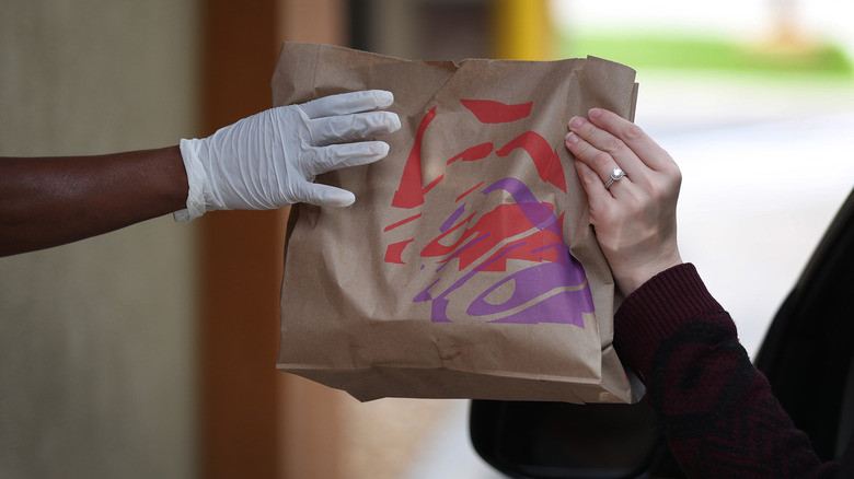 Person picking up a bag of food 