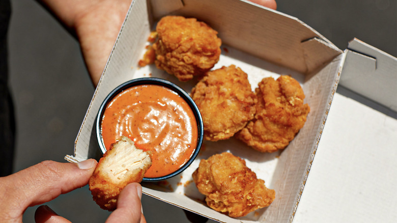 Hand dipping taco bell nuggets