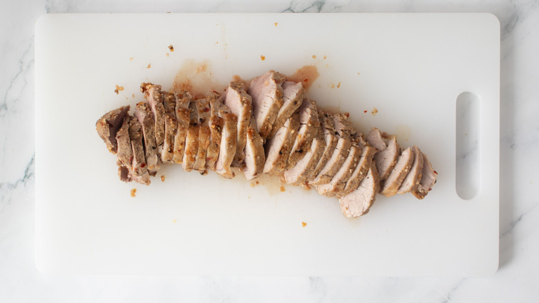 Sliced pork tenderloin on cutting board