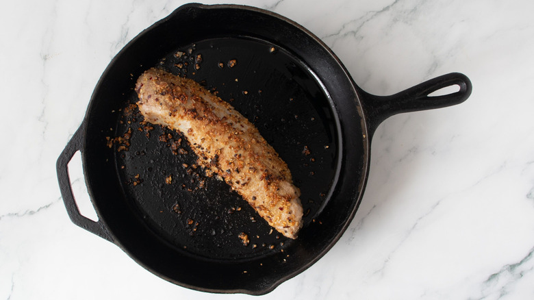 Seared pork tenderloin in skillet