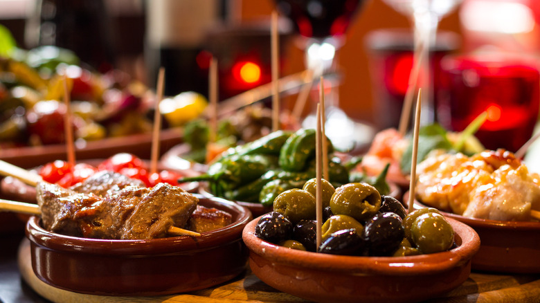 Small ceramic dishes of olives and other tapas with toothpicks