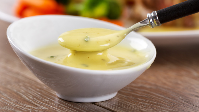 spooning béarnaise sauce from bowl