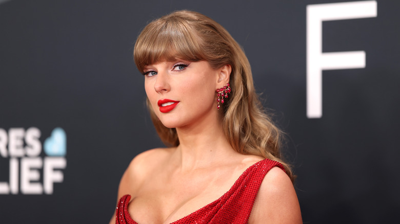 taylor swift smiling on red carpet wearing red