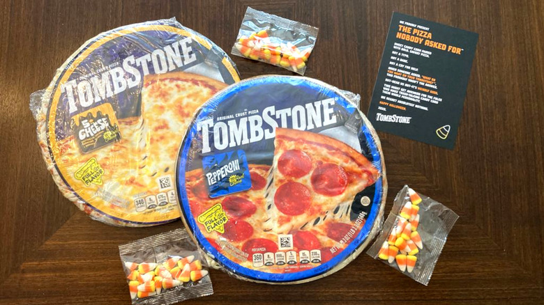 Two Tombstone pizzas in the packaging with three candy corn bags