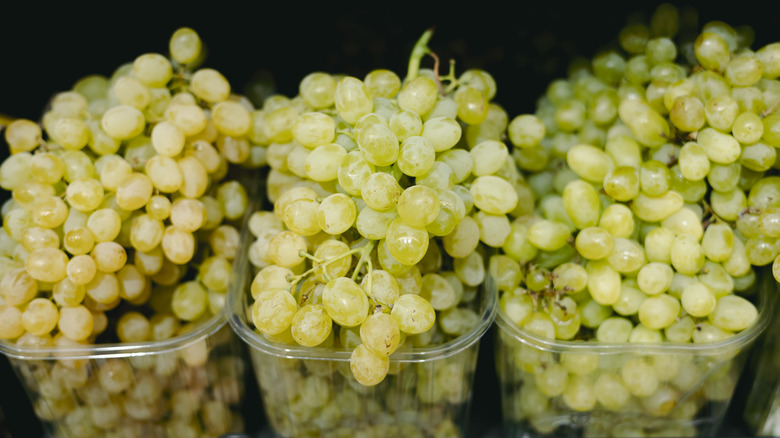 Bunches of green grapes in plastic containers