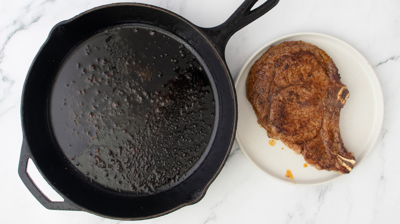 seared steak on plate next to cast iron skillet