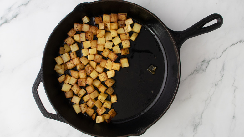 browned potatoes on side of skillet