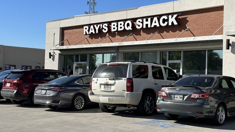 Cars parked in front of a strip center eatery.