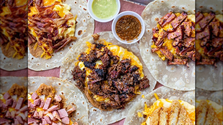 The Pit Room brisket taco open on a table with other tacos.