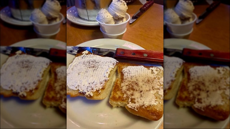 Two grilled dinner rolls with butter on plate at Texas Roadhouse