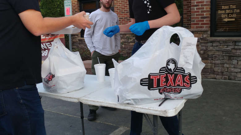 Customer picking up a Texas Roadhouse order to go