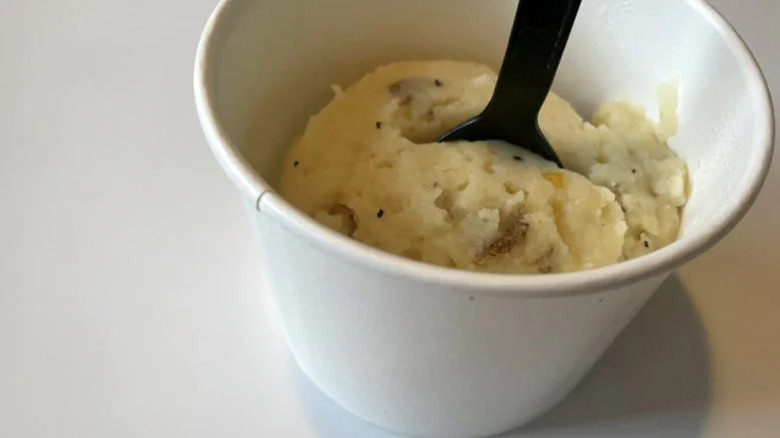 Outback mashed potatoes in a to-go cup with a plastic spoon in it