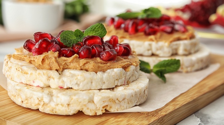 rice cakes topped with peanut butter and pomegranate seeds