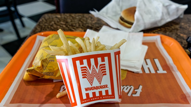Whatburger fries and burger on a tray on a table
