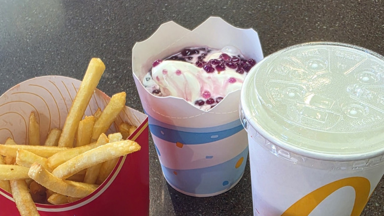 A McDonald's Derpy McFlurry beside an order of fries and a fountain drink on a counter