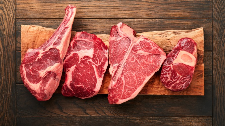 variety of raw steaks on a cutting board