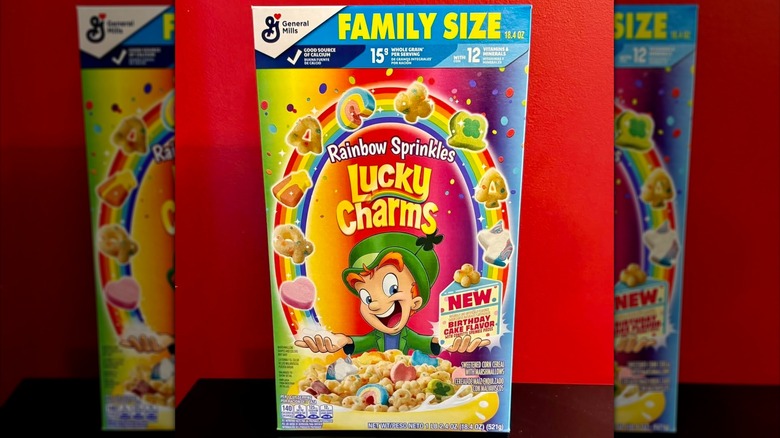 Lucky Charms rainbow sprinkles birthday cake cereal against red wall
