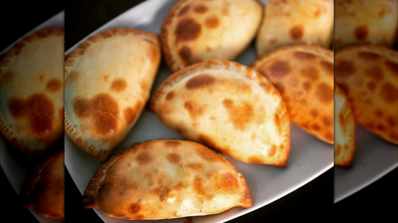 a tray of golden brown empanadas
