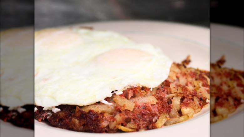 corned beef hash topped with an egg on plate