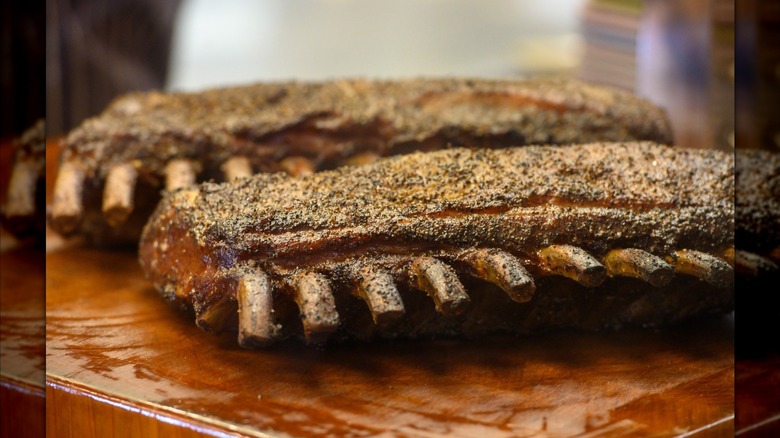 two slow smoked racks of ribs on cutting board
