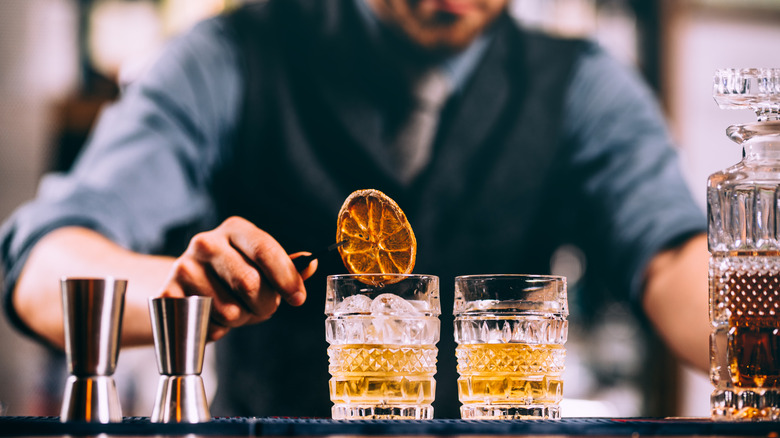 A bartender making old fashioneds