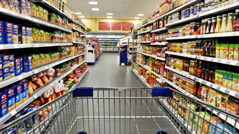 grocery aisle shelves with cart