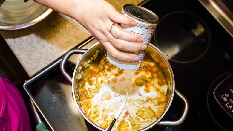 canned soup poured into pot