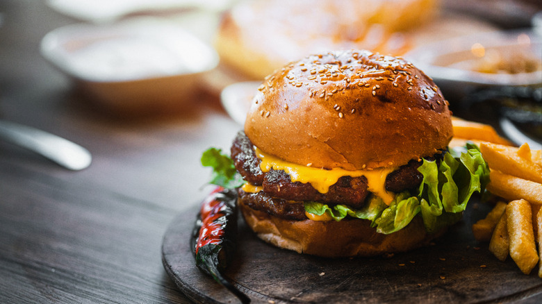 cheeseburger french fries on wood board