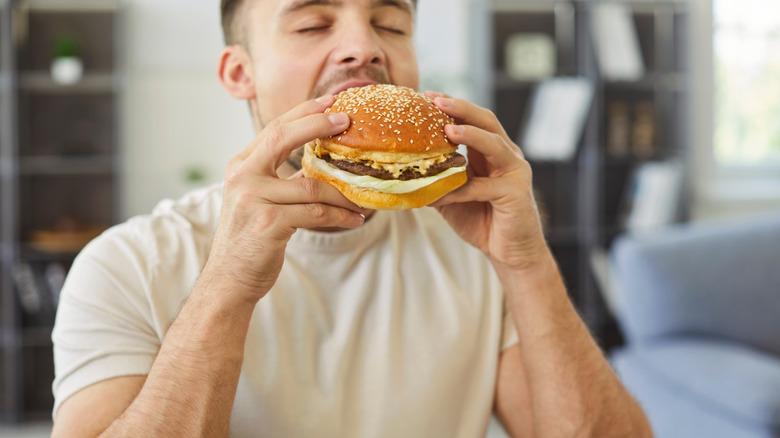 a man eating a cheeseburger