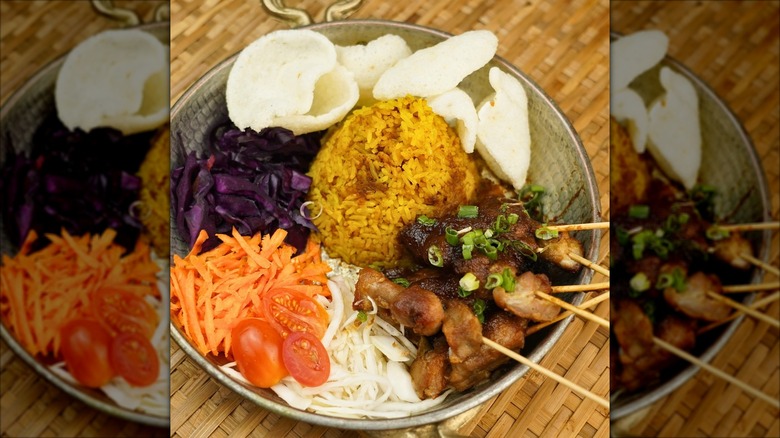 meat skewers, rice, and a side of vegetables in bowl on bamboo placemat