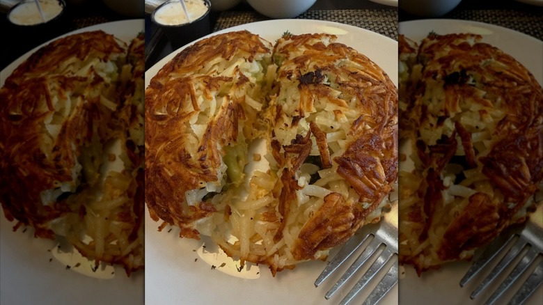 Signature rostis dish at Mrs. Potato restaurant, stuffed hashbrowns on white plate with fork