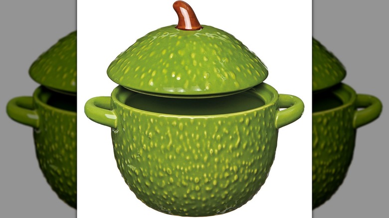 Avocado shaped ceramic bowl with lid and handles on either side.