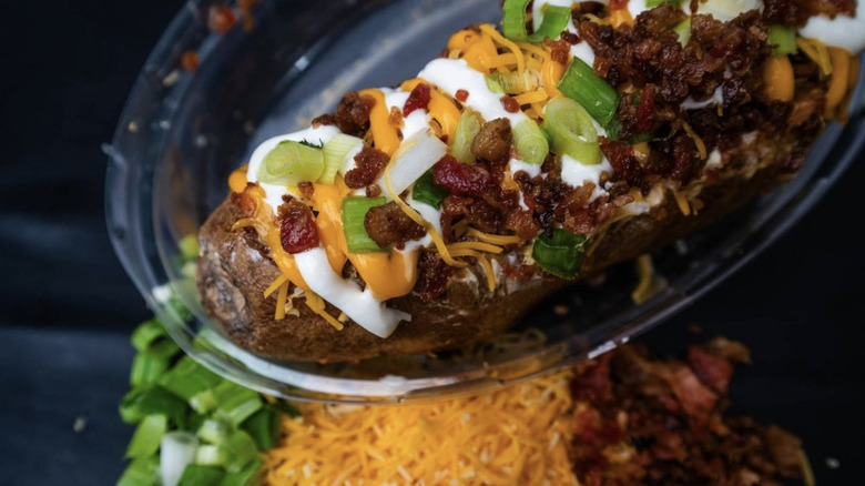 baked potato with bacon, chives, cheese, and sour cream