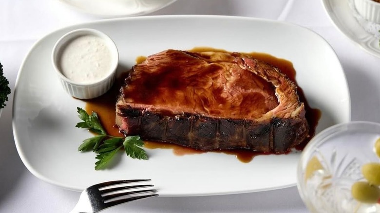 Prime rib served with au jus and side of dipping sauce on plate at Tortoise Supper Club